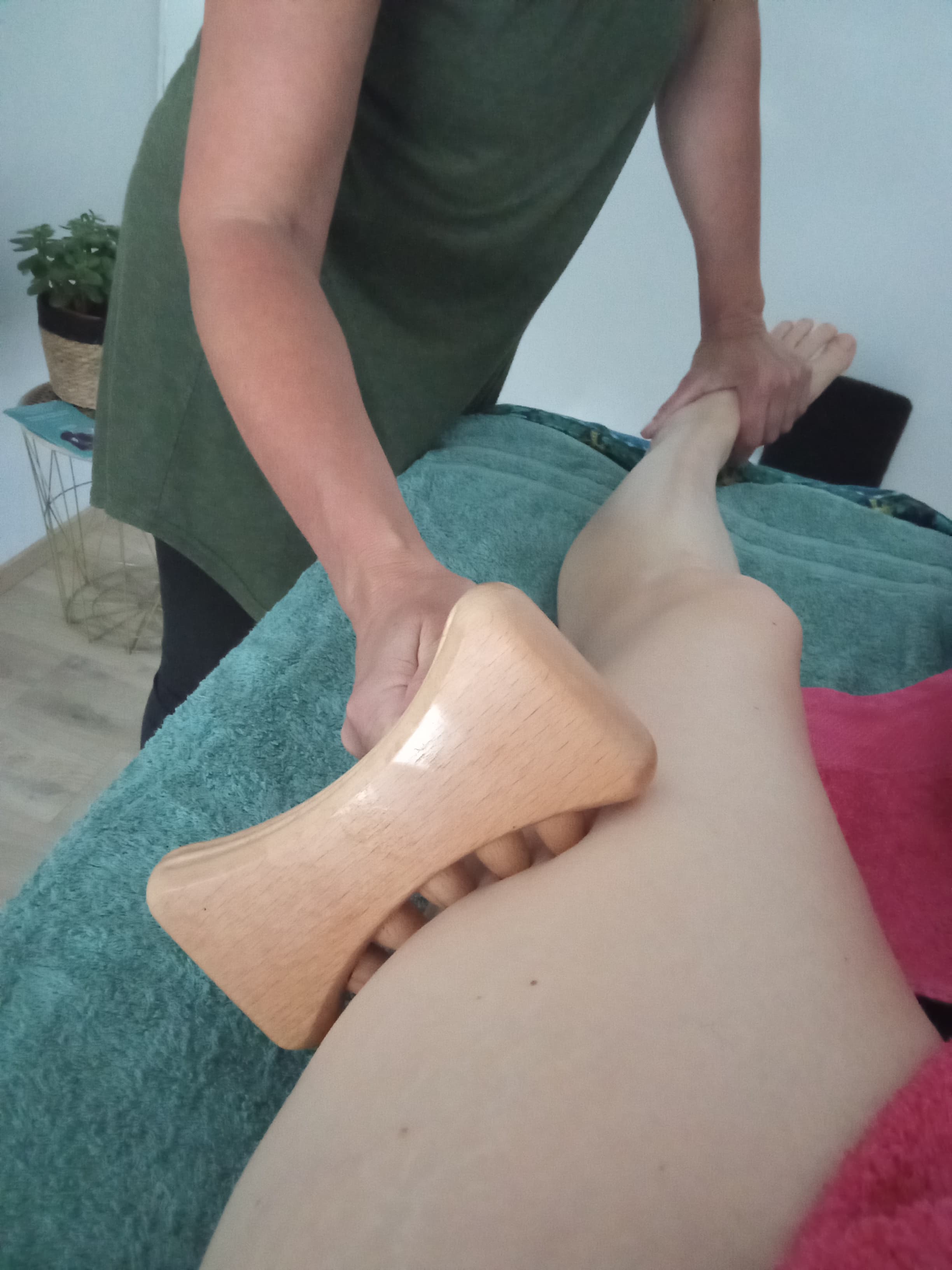 Séance de réflexo-madéro au cabinet ISAYIA — outil en bois sur la jambe